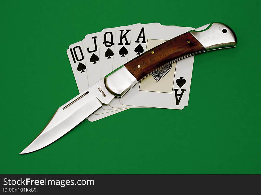 Playing cards and knife isolated over green background. Playing cards and knife isolated over green background