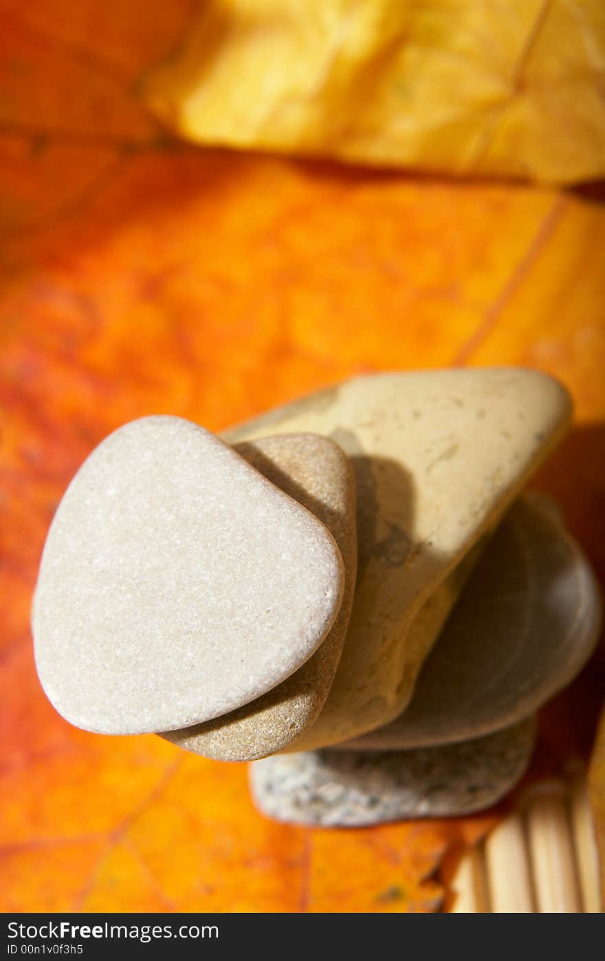 Five flat stones over autumn leaves. Five flat stones over autumn leaves