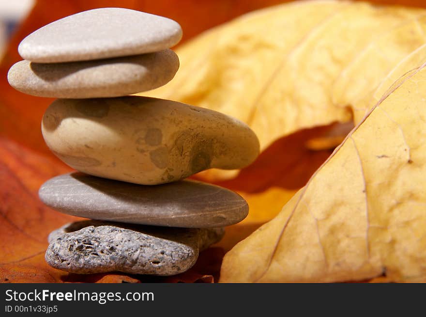 Five flat stones over autumn leaves. Five flat stones over autumn leaves