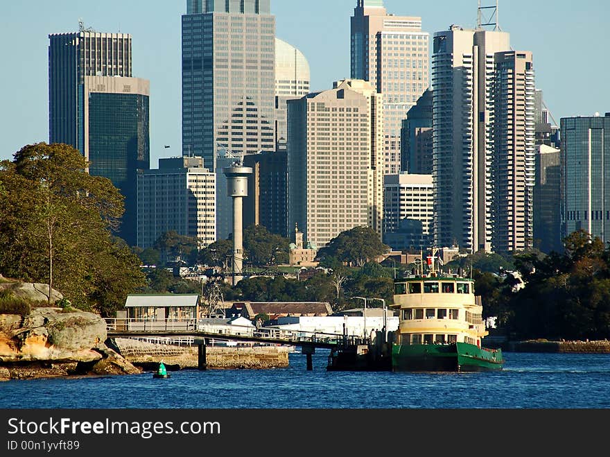 A view over a city over with harbour and ferry foreground. A view over a city over with harbour and ferry foreground