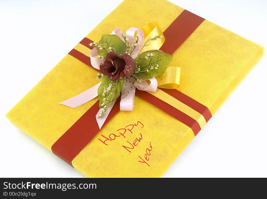 Yellow gift box with red ribbon and flower