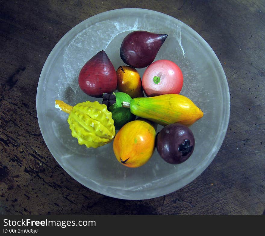 Wooden fruit in a glass plate