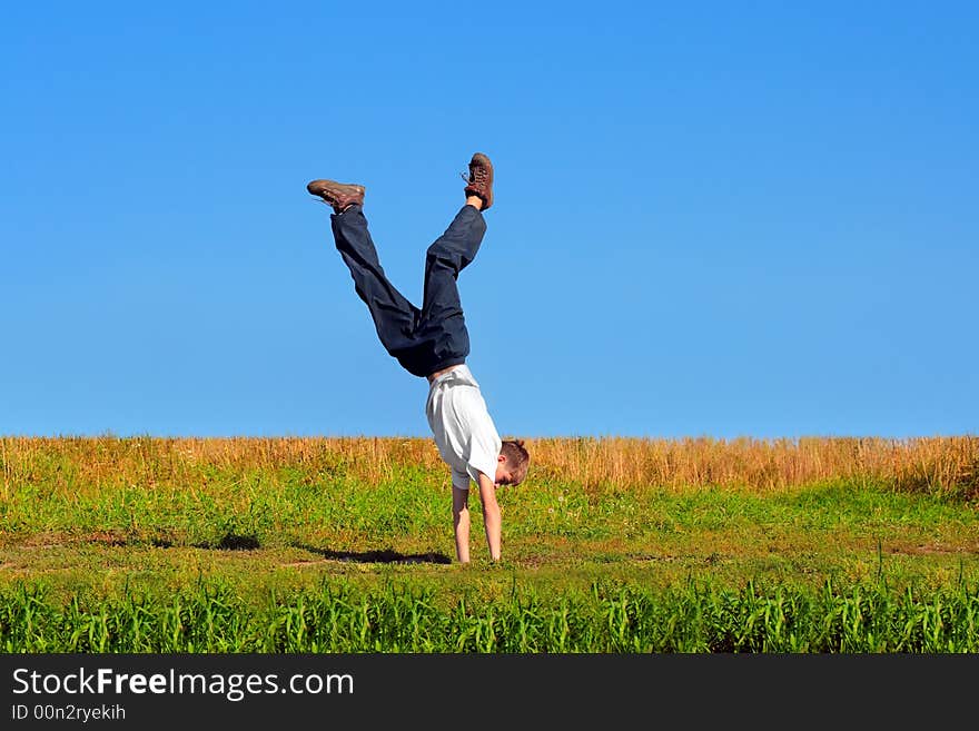 Somersault on grass on the blue sky background. Somersault on grass on the blue sky background