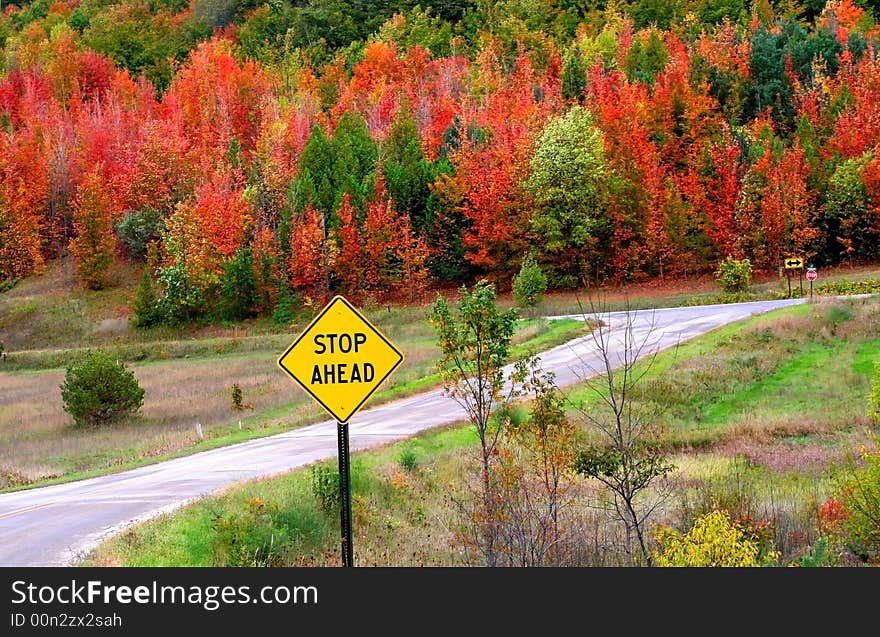 Stop ahead sign in the middle of beautiful autumn landscape