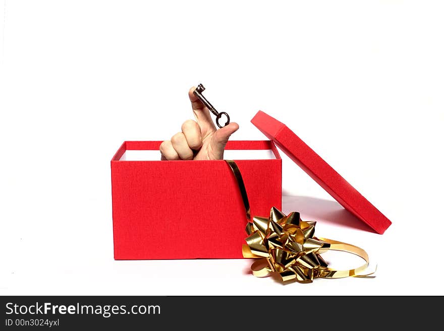 A key being held from inside a gift box. A key being held from inside a gift box