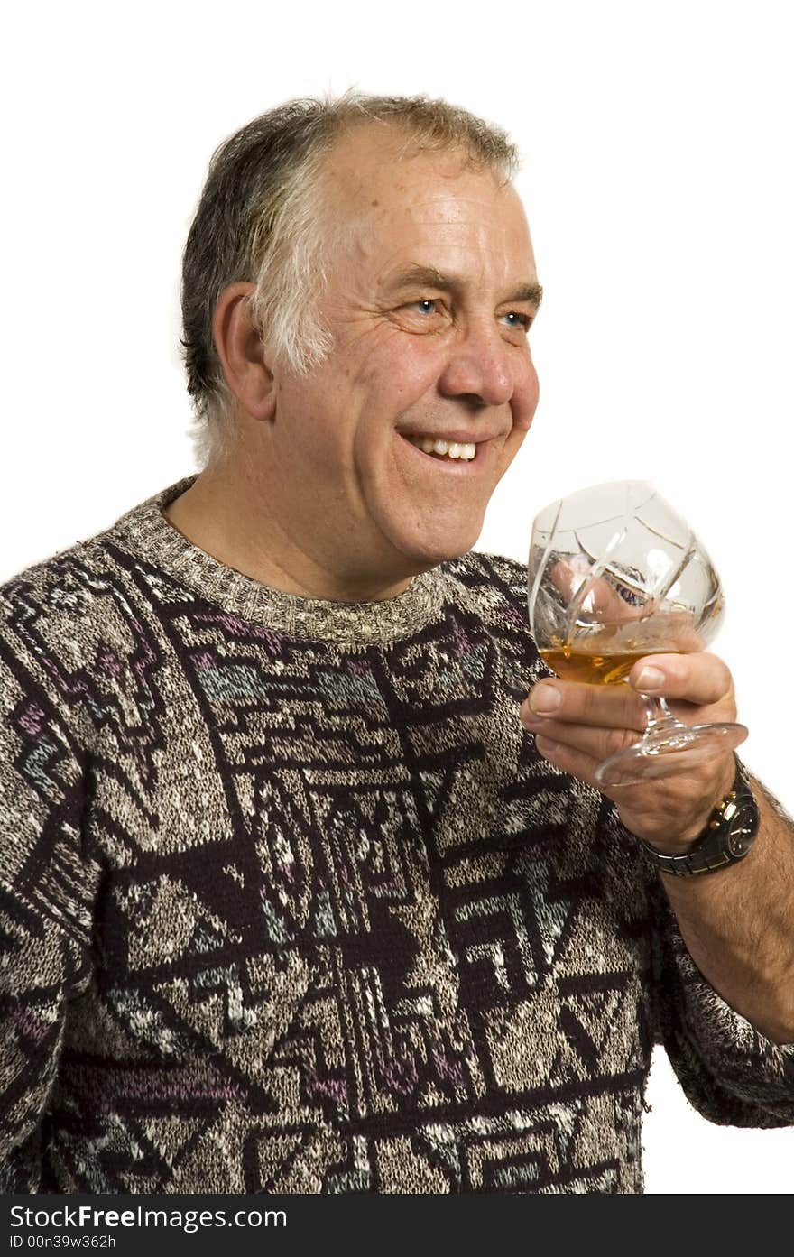 Smiling and happy older man drinking single malt scotch from a crystal glass - isolated on white. Smiling and happy older man drinking single malt scotch from a crystal glass - isolated on white