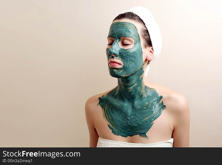 Beautyful young woman with green moisturizing facial cream. Beautyful young woman with green moisturizing facial cream