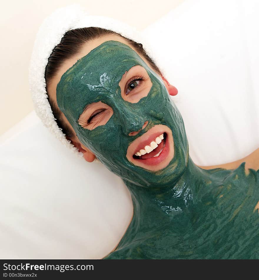 Beautyful young woman with green moisturizing facial cream. Beautyful young woman with green moisturizing facial cream