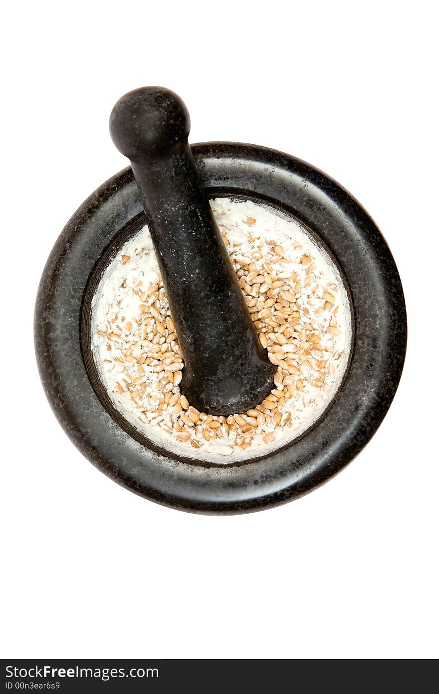 Grinding wheat in a kitchen pestle. Isolated on a white background.