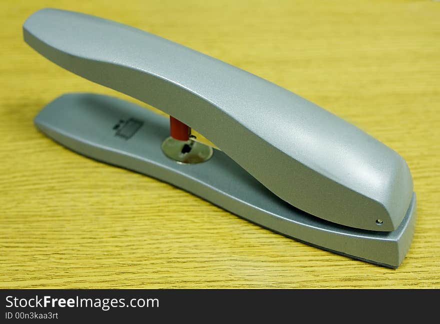 Silver coloured stapler on an office desk nice colours. Silver coloured stapler on an office desk nice colours