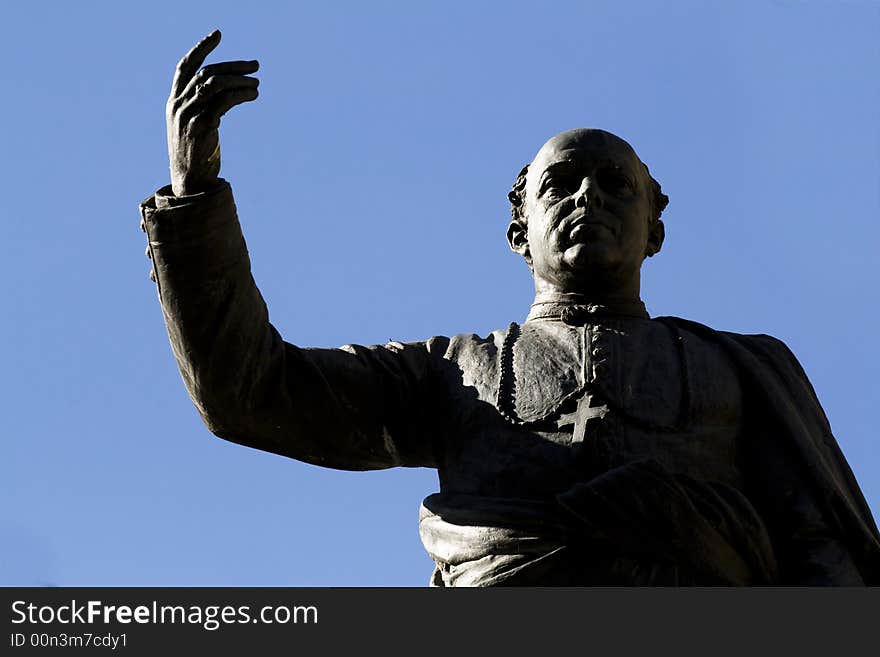 A bishop statue with a hand up situated in Salamanca, Spain.