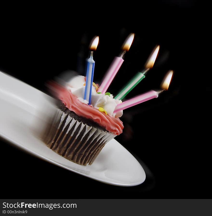 Cupcake starting to fall from a plate. Cupcake starting to fall from a plate.