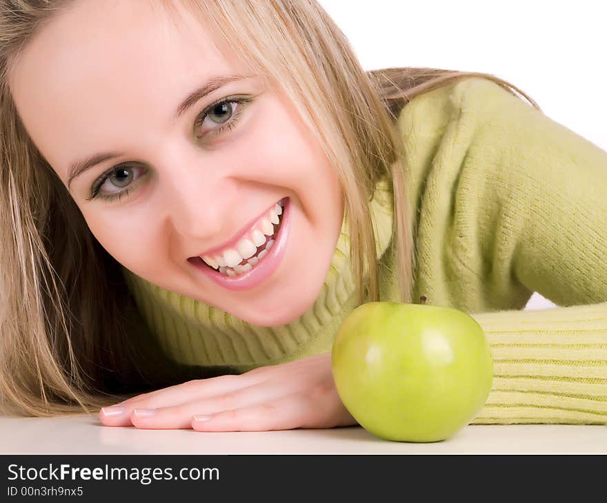 Smilling student and green apple on the table