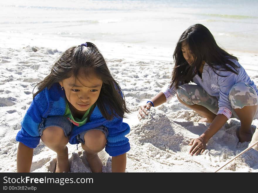 Picture of two kids playing with the sand on the beach. Picture of two kids playing with the sand on the beach