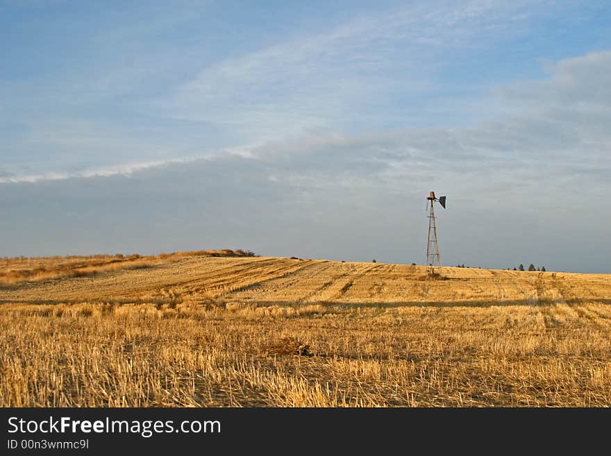 An agricultural scene with an old windmill in the evening light. An agricultural scene with an old windmill in the evening light.