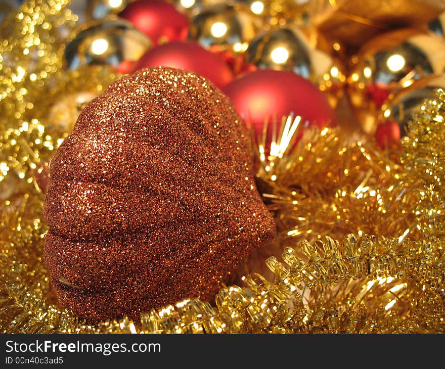 Bronze christmas toy on golden and red balls and glare background