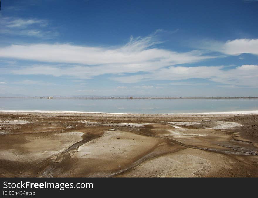 White salt lake under blue sky, fissured soil. White salt lake under blue sky, fissured soil