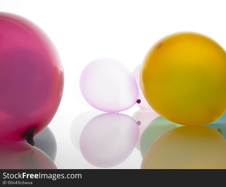 Coloured balloons lying on a white surface.