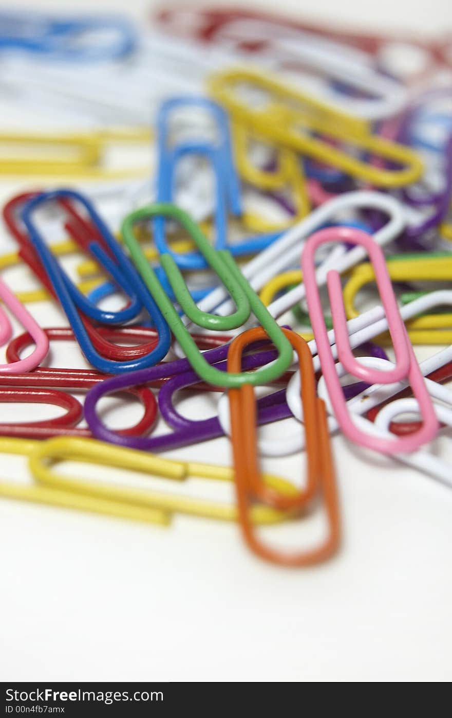 A lot odcolored paper clips isolated on white. A lot odcolored paper clips isolated on white