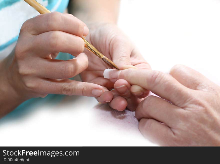 Manicurist treating customer at beauty salon