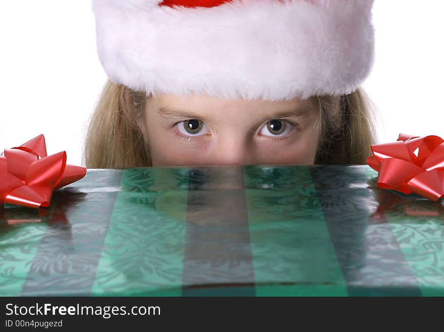 Shot of a Little girl peeking over present. Shot of a Little girl peeking over present