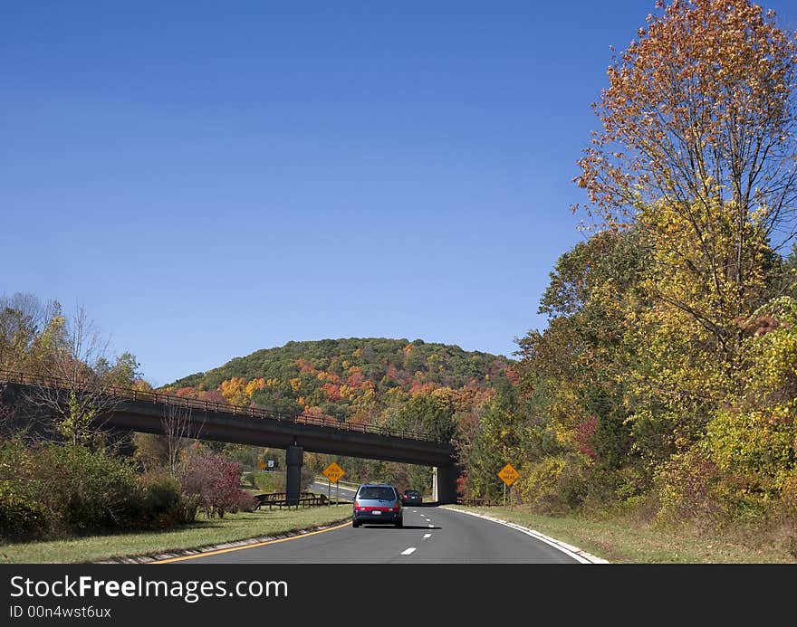 Landscape with road, bridge, cars and autumn leaves on a sunny day. Landscape with road, bridge, cars and autumn leaves on a sunny day