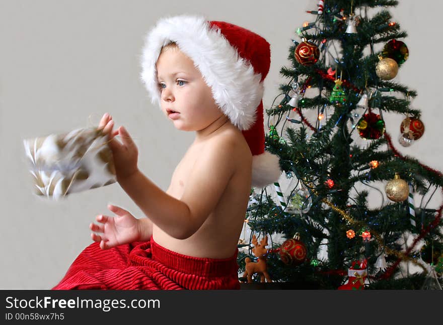 Toddler with a Christmas hat and red trousers. Toddler with a Christmas hat and red trousers