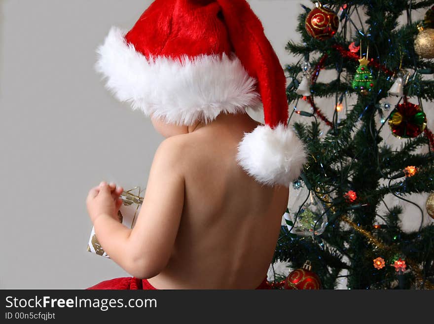 Toddler with a Christmas hat and red trousers. Toddler with a Christmas hat and red trousers