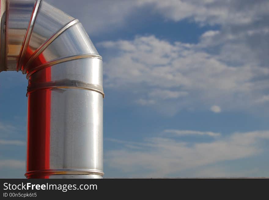 The metal tube of an hydrant reflecting its red box and the light from the sun