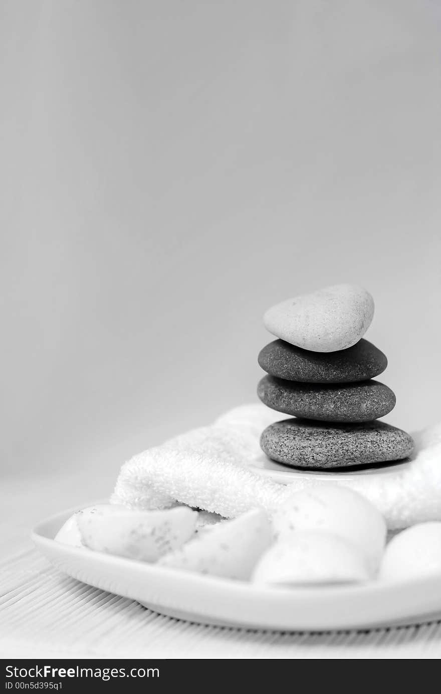 Natural oil soaps with pebble stones and white towel in black and white tones. Natural oil soaps with pebble stones and white towel in black and white tones