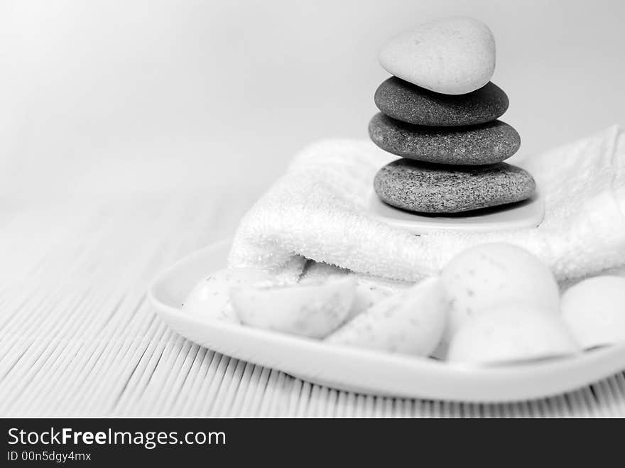 Natural oil soaps with pebble stones and white towel in black and white tones. Natural oil soaps with pebble stones and white towel in black and white tones