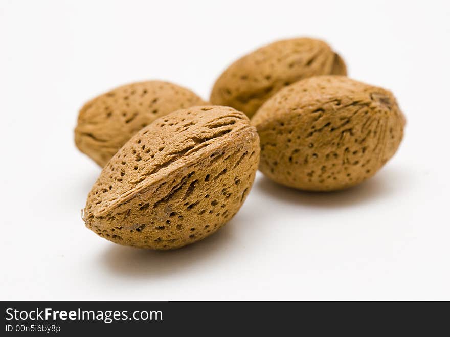 Four almonds on a white table