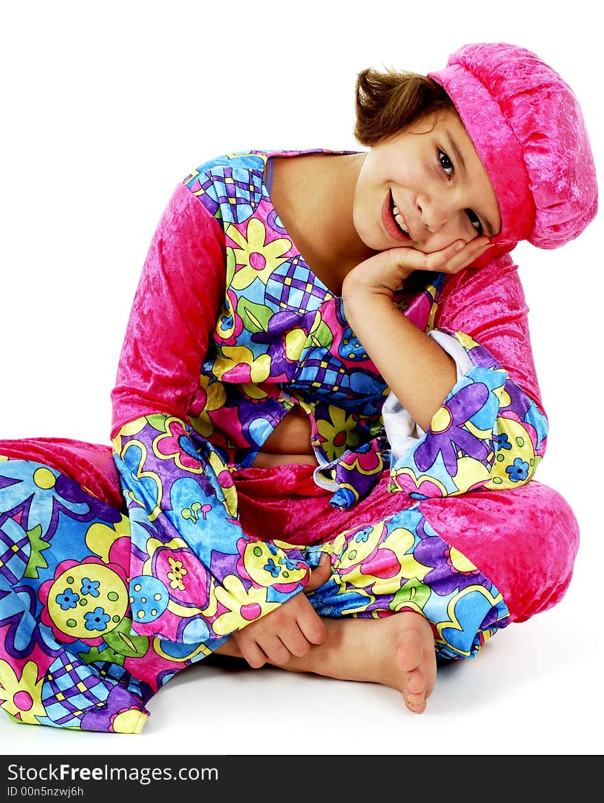 Portrait of a happy preteen girl sitting cross-legged in colorful hippie attire. Portrait of a happy preteen girl sitting cross-legged in colorful hippie attire.