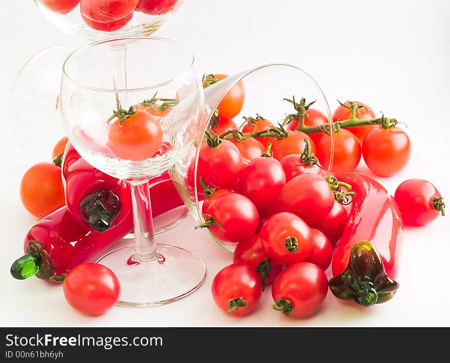 A riot of cherry tomatoes - of two varieties, one on vine - and wine glasses and glass chilies, suggesting salsa, bloody marys, and party and fun. A riot of cherry tomatoes - of two varieties, one on vine - and wine glasses and glass chilies, suggesting salsa, bloody marys, and party and fun.