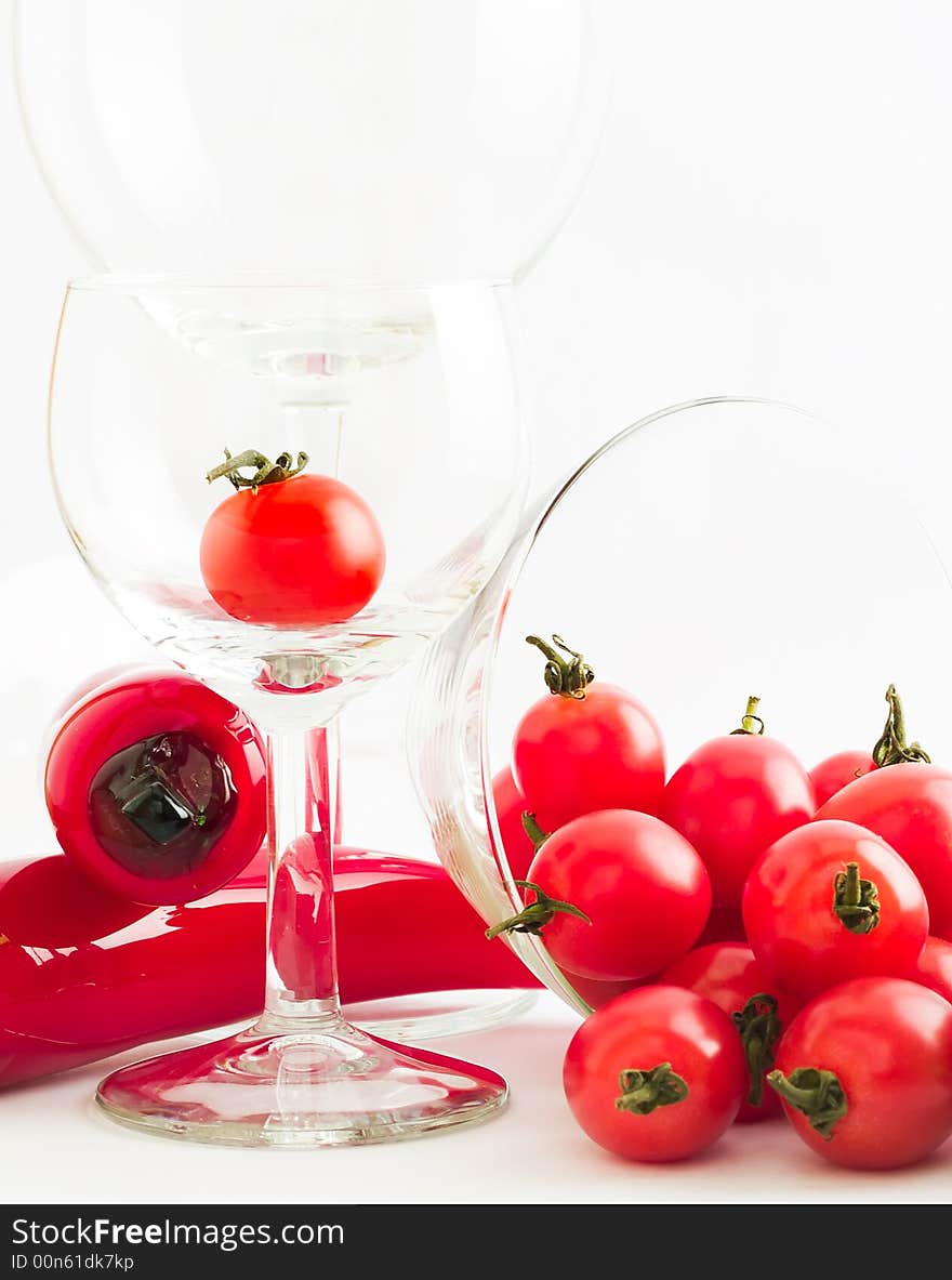 Still life of a riot of cherry tomatoes, wine glasses and glass chilies, suggesting salsa, bloody marys, and party and fun. Still life of a riot of cherry tomatoes, wine glasses and glass chilies, suggesting salsa, bloody marys, and party and fun.