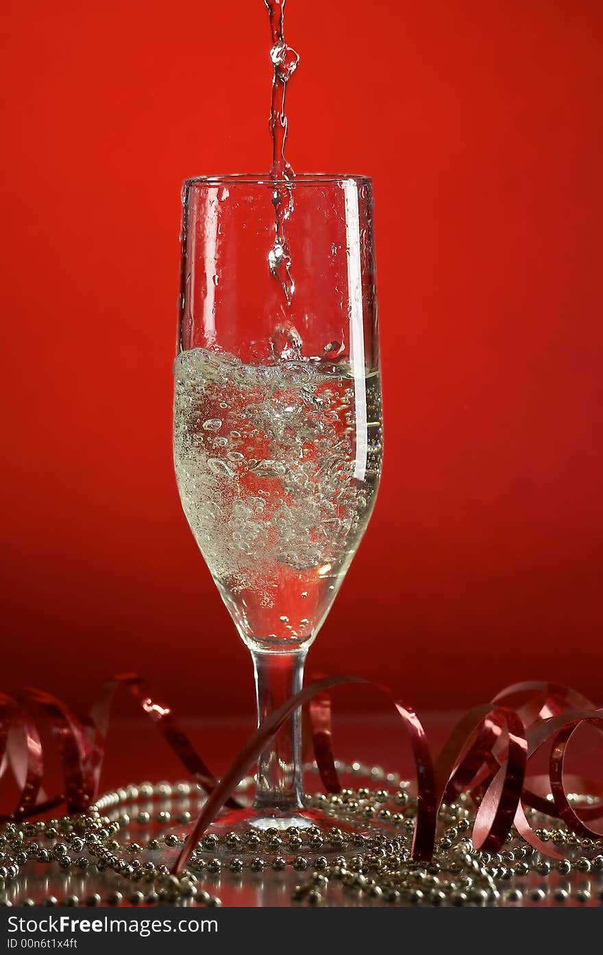 Still life with glass with champagne on the red background