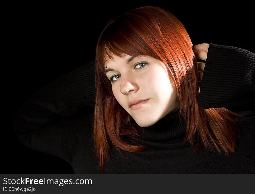 Red hair girl with hands behind head smiling, serene.

Shot in studio.