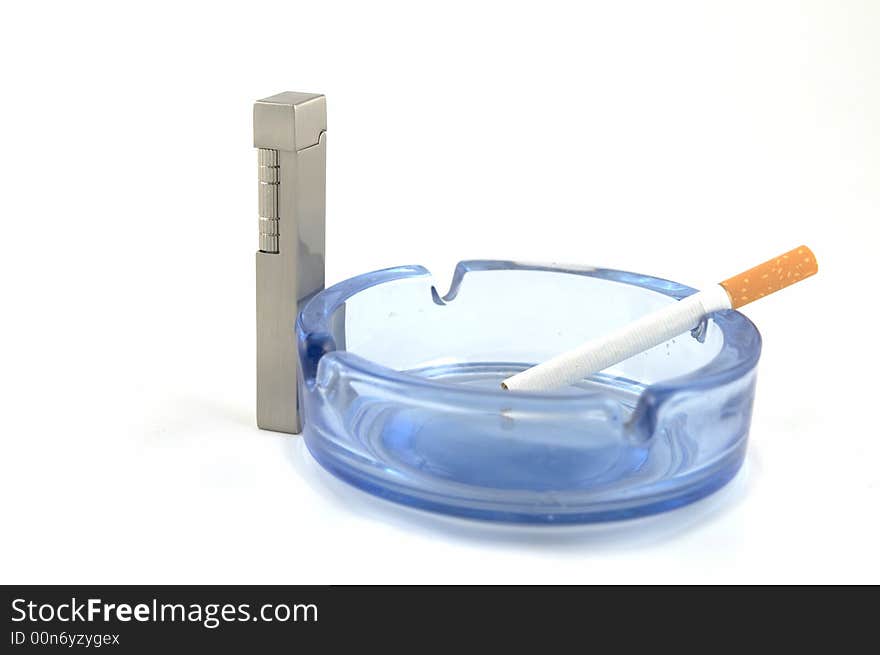 Glass ashtray with a lighter and a cigarette. Glass ashtray with a lighter and a cigarette