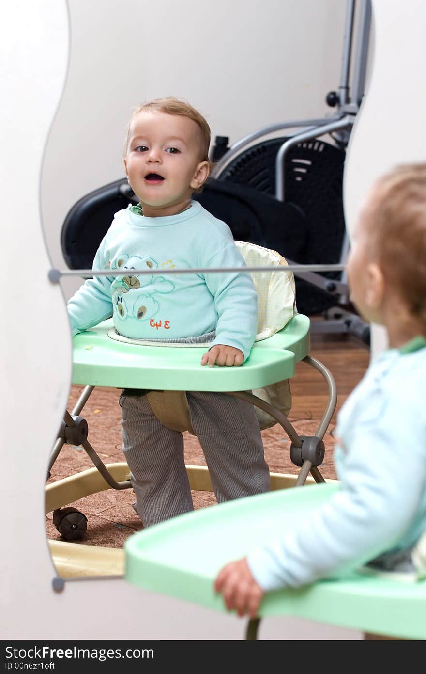 Cute blond kid smiling to his reflection. Cute blond kid smiling to his reflection