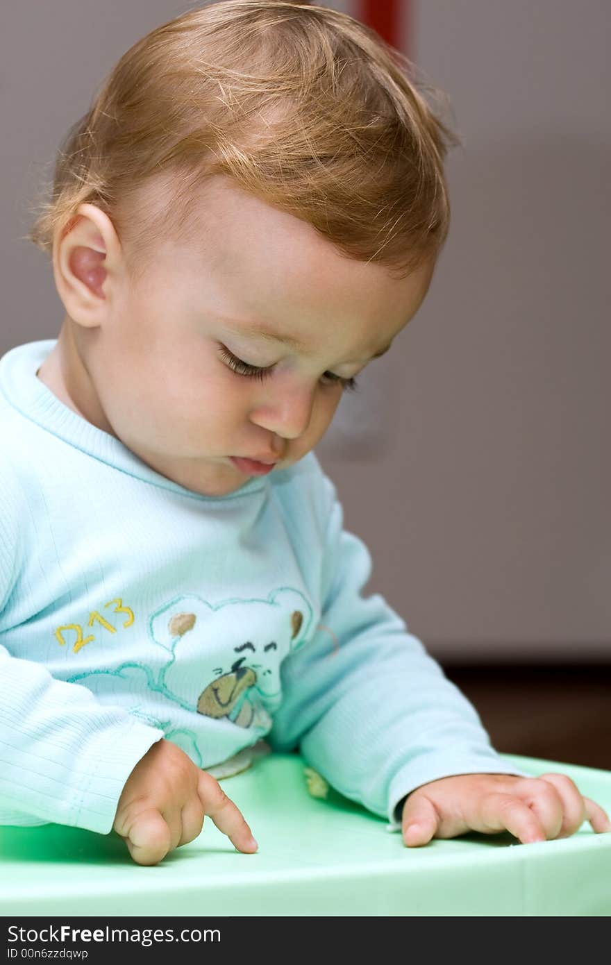 Cute small child pointing his finger on a green board. Cute small child pointing his finger on a green board