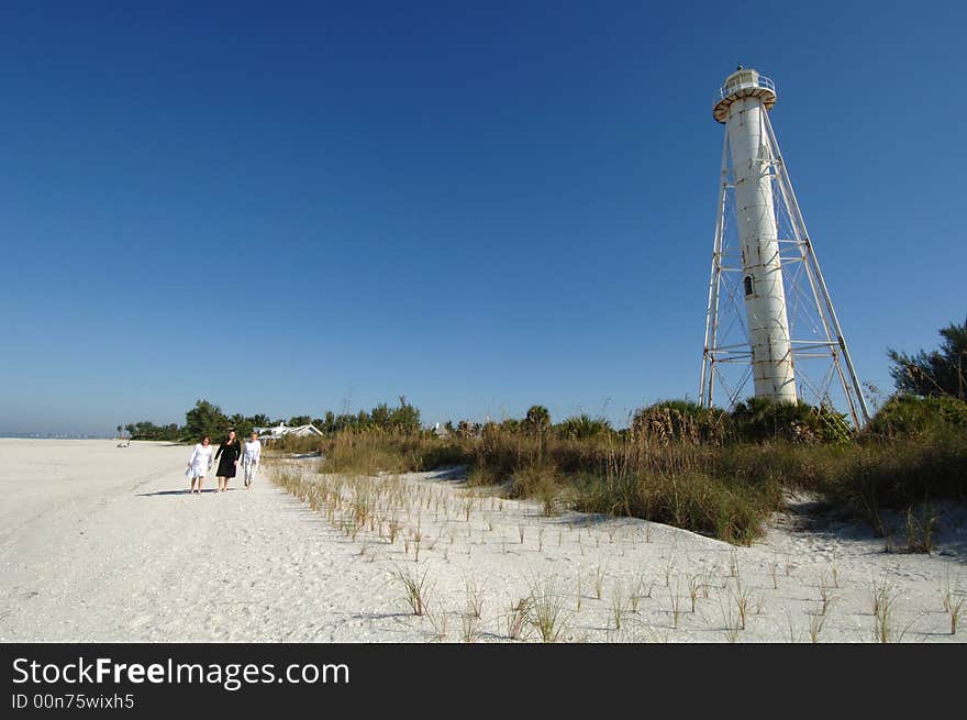 Three women walking along beach near lighthouse in Boca Grande Florida. Three women walking along beach near lighthouse in Boca Grande Florida.