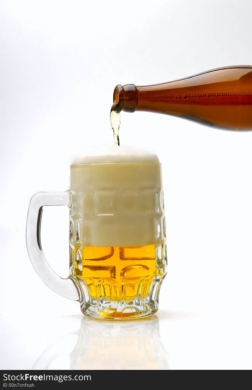 Fresh golden beer in a mug on a white background