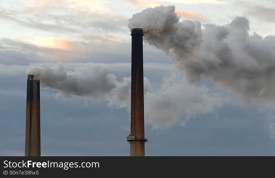 Two smokestacks billowing clouds of fumes adding to global warming. Two smokestacks billowing clouds of fumes adding to global warming