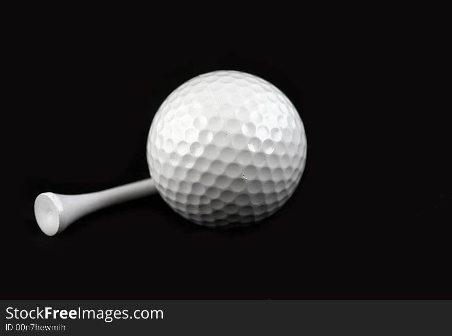 Golf ball and golf tee on black background. Golf ball and golf tee on black background