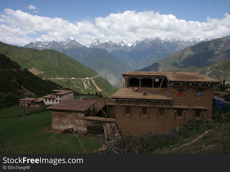 Traditional Tibetan house, with majestic tall mountains in the background. Traditional Tibetan house, with majestic tall mountains in the background