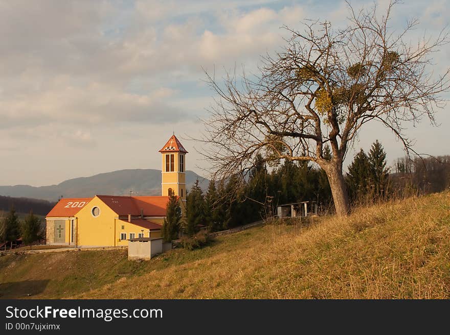 Church with tree and cloudy sky