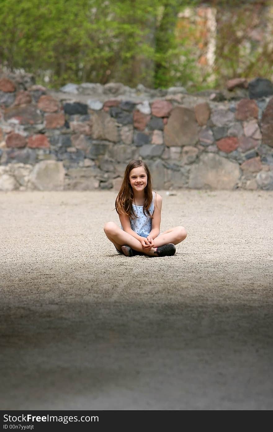 Girl sitting cross-legged on the sand