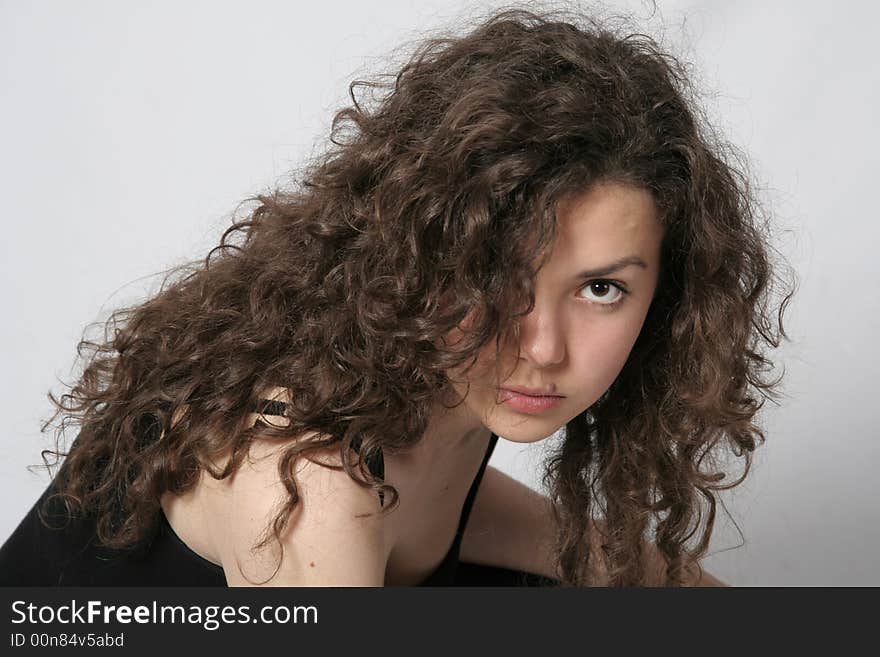 Portrait of a beautiful young brunette woman with curly hair