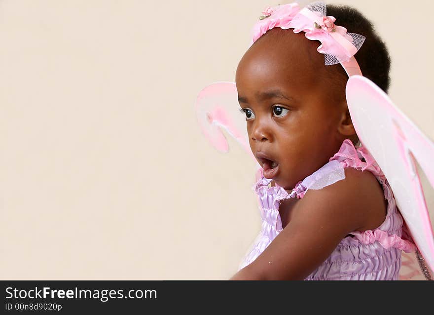 Toddler girl in a pink fairy costume with wings and head piece. Toddler girl in a pink fairy costume with wings and head piece