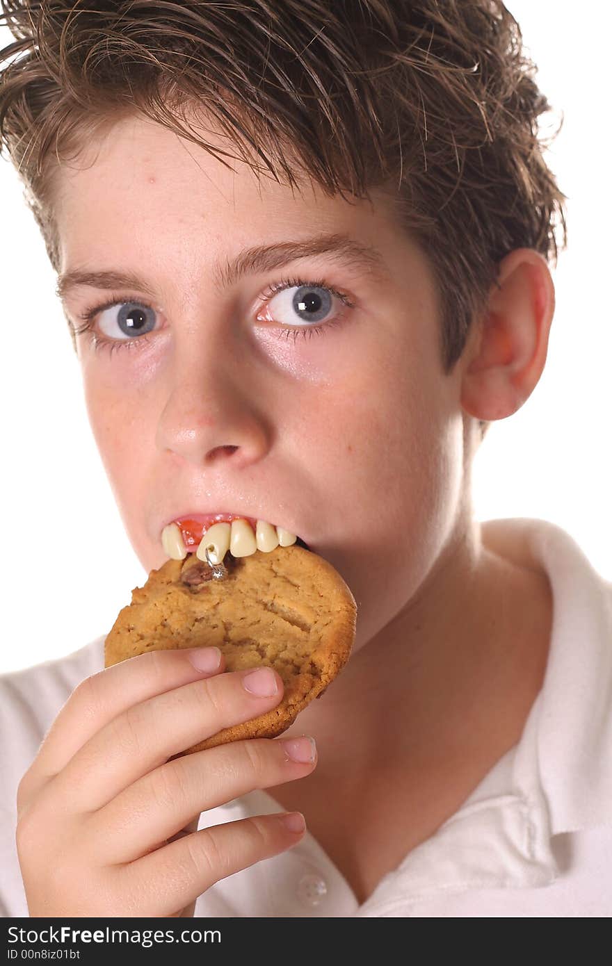 Shot of a young boy with rotten teeth eating a cookie